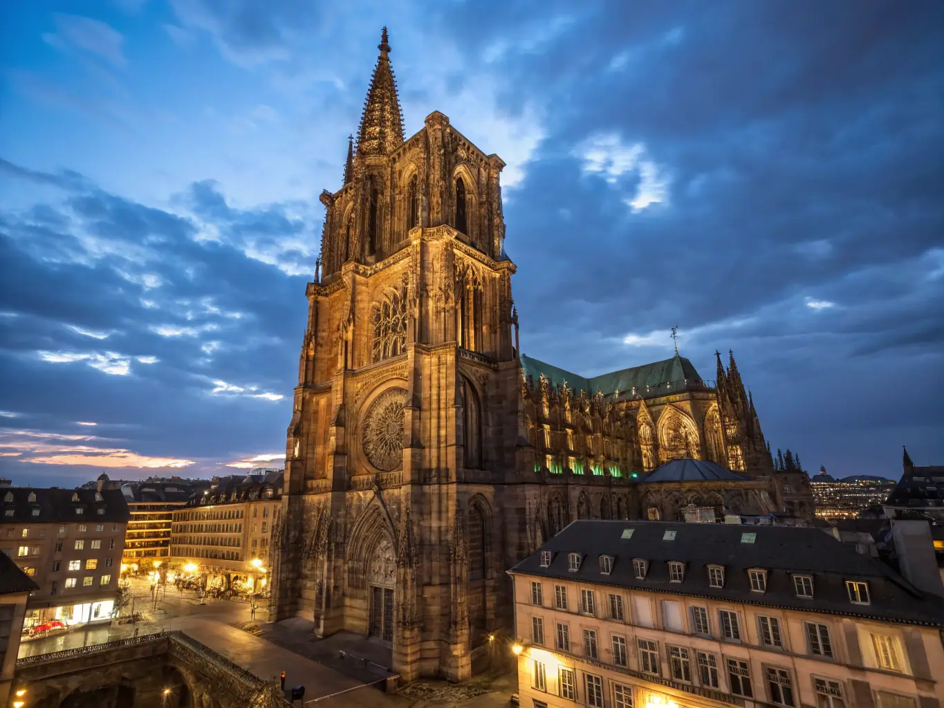 A detailed photograph of the Strasbourg Cathedral, showcasing its intricate Gothic architecture and towering spire.